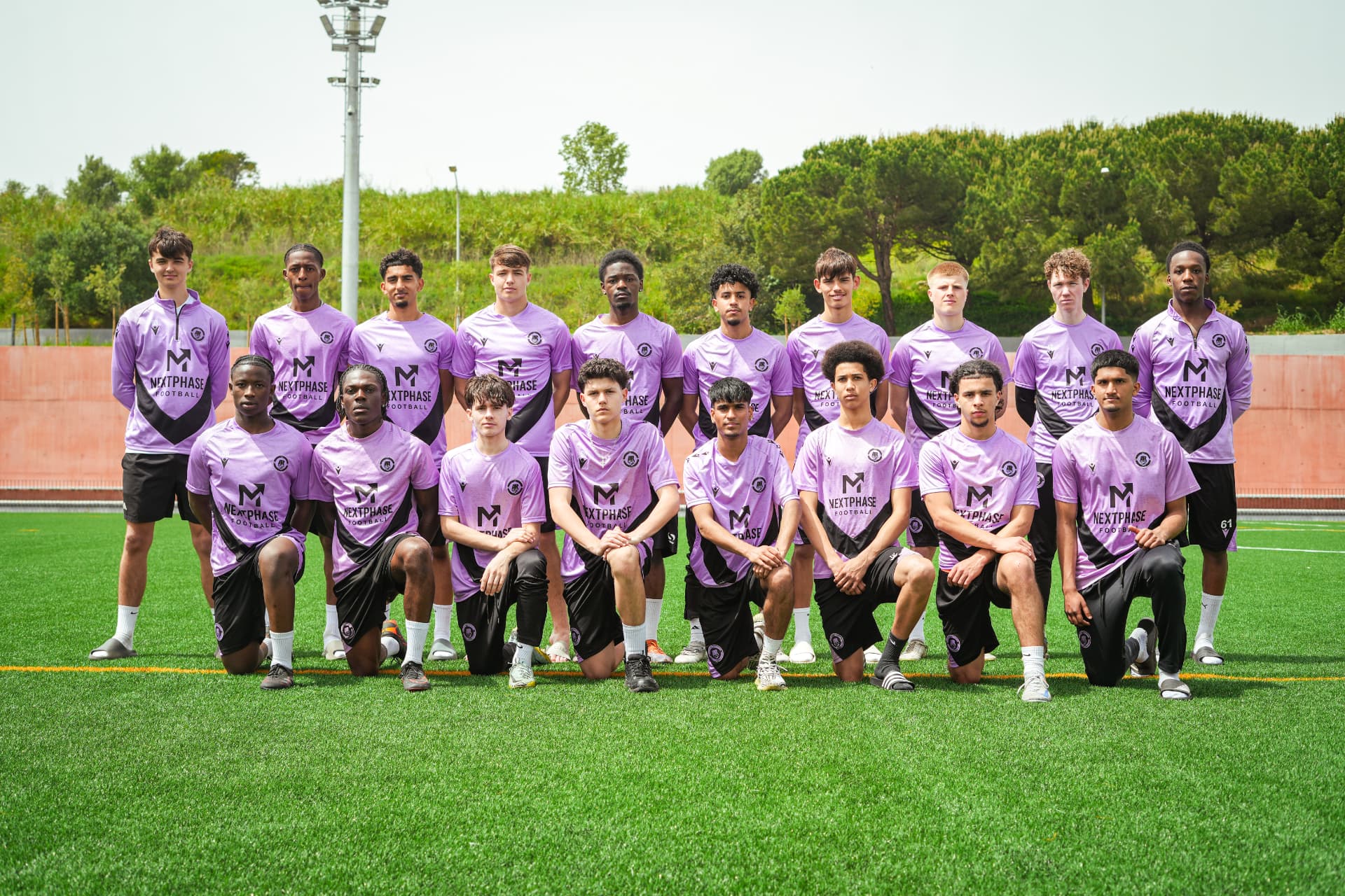 Full Next Phase Football squad photograph on a training pitch in matching branded kit.
